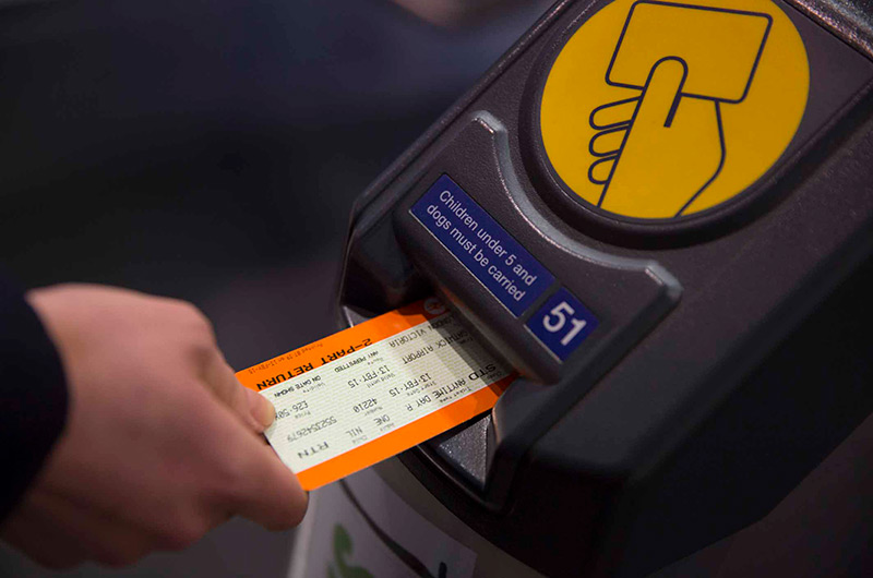 Image showing passenger inserting ticket into barrier in London Gatwick train station
