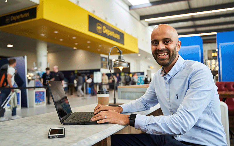 Man using his laptop in a departures lounge