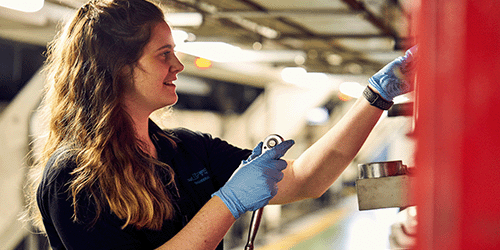Photo of a young female Gatwick engineer with a wrench and gloves