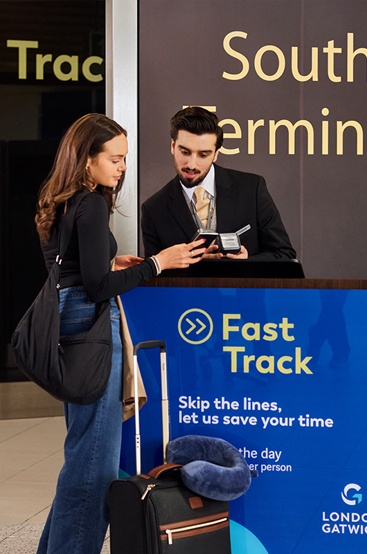 Passenger presenting their booking and passport to the London Gatwick Fast Track Security staff member