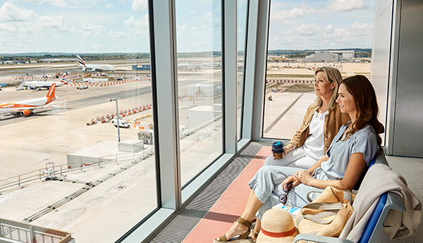 Image showing passengers looking out over the airfield, relaxed before their flight