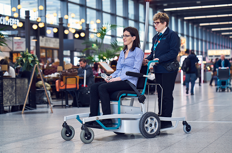 Image showing Special Assistance host pushing customer in wheelchair at London Gatwick
