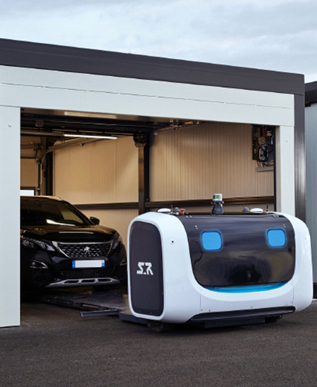 A robot carefully pulling a car out of a covered bay at Gatwick Airport's Robotic Parking