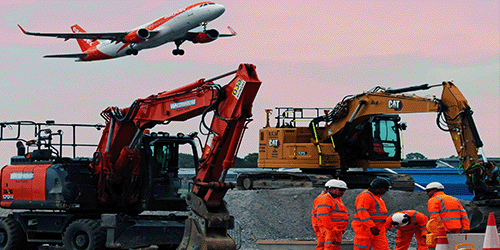 Construction workers and machinery on Gatwick's Northern runway, with an easyJet plane taking off in the background
