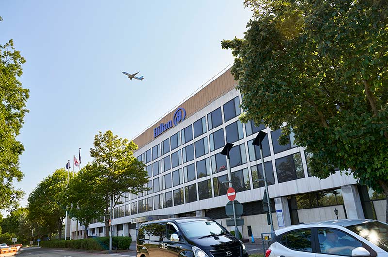 Image showing Hilton hotel at London Gatwick South Terminal with aircraft taking off overhead