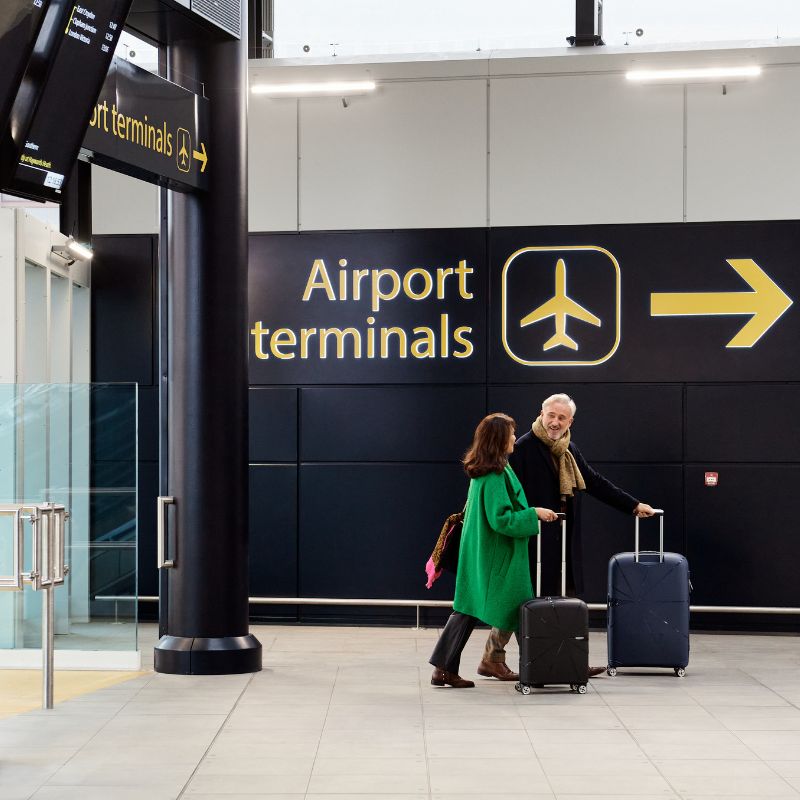 A couple walking to London Gatwick terminals from the train station