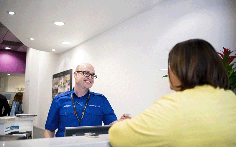 A photo of an ID centre colleague speaking with a client