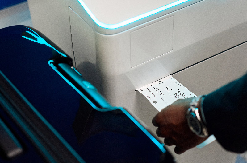Passenger receiving their printed boarding pass from self-service terminal